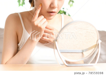 鏡を見ながら肌トラブルに悩む女性 78559398