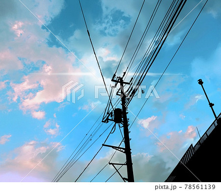 青空に浮かぶ雲と太陽光と電信柱のシルエットのイラスト素材