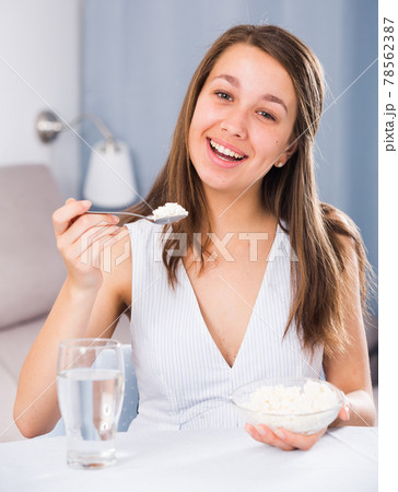 Female teenager is enjoying tasty curd Female teenager is enjoying tasty curd 78562387
