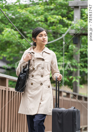 吊橋でスーツケースクを持って歩くビジネスウーマン 78563747
