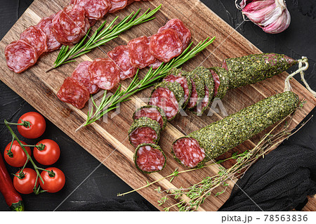 Spanish fuet salami sausage slices on black textured background 78563836