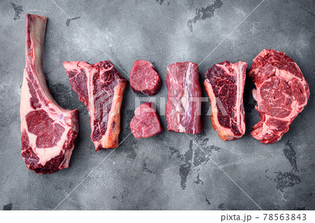 Various cuts of marbled beef meat and dry aged steaks, tomahawk, t bone, club steak, rib eye and tenderloin cuts, on gray stone background, top view flat lay, with copy space for text Various cuts of marbled beef meat and dry aged steaks, tomahawk, t bone, club steak, rib eye and tenderloin cuts, on gray stone background, top view flat lay, with copy space for text 78563843