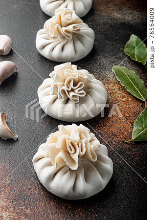 Stuffed dumplings, manti of dough and minced , on old dark rustic background Stuffed dumplings, manti of dough and minced , on old dark rustic background 78564009
