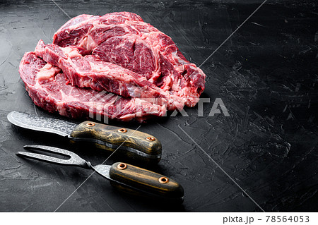 Raw marbled steak, Rib eye cut, on black stone background Raw marbled steak, Rib eye cut, on black stone background 78564053