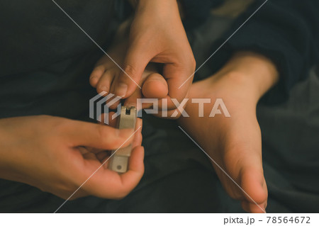 子供の足の爪を切る母親 78564672