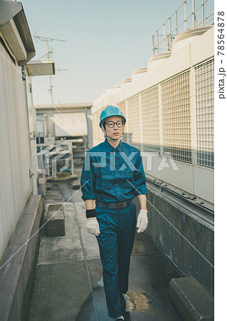 ビル屋上の空調設備を点検する業者の写真素材