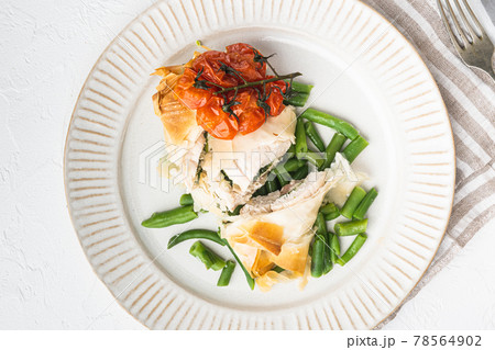 Chicken Kiev with wild garlic, with baked cherry tomatoes And green beans, on white stone background, top view flat lay 78564902