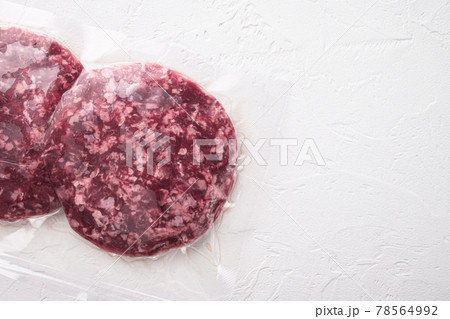 Burger meat vacuum sealed ready for sous vide cooking, on white stone background, top view flat lay, with copy space for text Burger meat vacuum sealed ready for sous vide cooking, on white stone background, top view flat lay, with copy space for text 78564992
