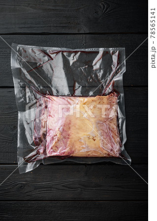 Marbled beef steak cut in vacuum pack, on black wooden background, on black wooden background, top view 78565141