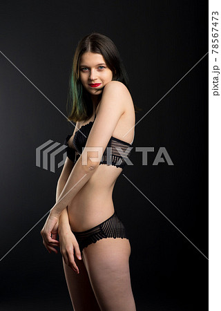 Vertical view photo beautiful shy lady in lace bikini boudoir bra panties. Tender skinny slim shape isolated black background. 78567473