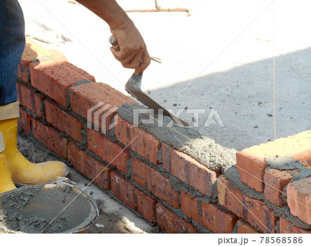 JOHOR, MALAYSIA -NOVEMBER 25, 2016: Bricklayer lay clay bricks block to form building walls at the construction site. JOHOR, MALAYSIA -NOVEMBER 25, 2016: Bricklayer lay clay bricks block to form building walls at the construction site. 78568586