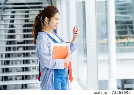 スマホを見る大学生 78568900