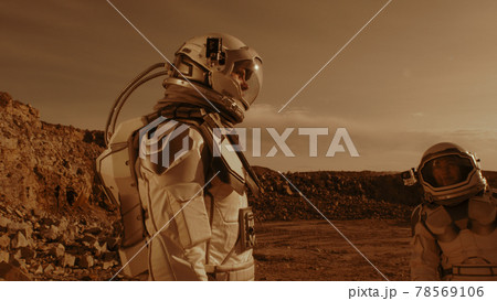 Male astronaut adjusting camera on colleague 78569106