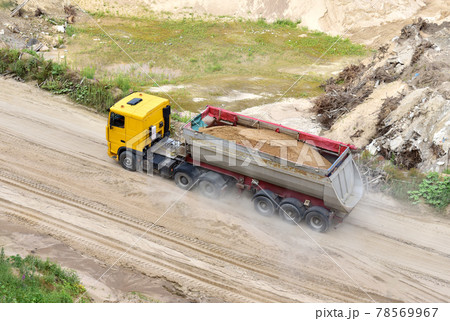 Truck with tipper semi trailer transported sand from the quarry. Dump truck working in open pit mine Truck with tipper semi trailer transported sand from the quarry. Dump truck working in open pit mine 78569967