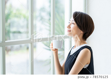 窓際でコーヒーを飲む女性 78570125