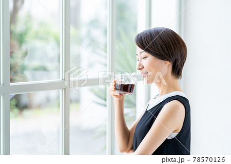 窓際でコーヒーを飲む女性 78570126