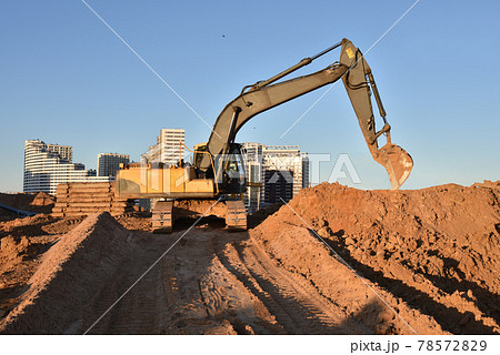 Excavator on earthworks at construction site. Backhoe on foundation work and road construction.  78572829