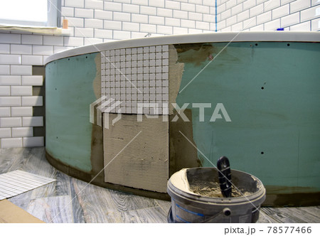 Laying ceramic tiles in the bathroom of a residential building. Installing Stone Glass Mosaic Tile 78577466