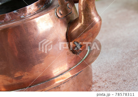 Old copper kettle on concrete background. Old copper kettle on concrete background. 78578311