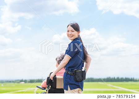 車椅子を押す介護士 78579154