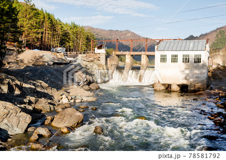 Old dam with flowing water on river. Hydroelectric power station, hydro energy. 78581792