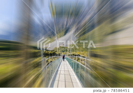 Travelers can seen trekking along to the Upper Hooker Bridge in motion blur, Mount Cook National Park,New Zealand. 78586451