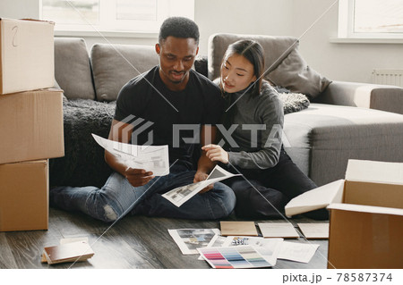 Diverse couple choosing design for new flat 78587374
