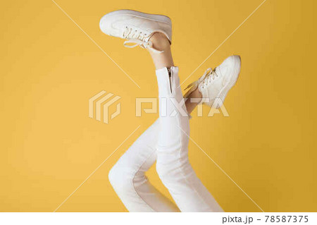 inverted legs in white sneakers fashion modern style yellow background 78587375