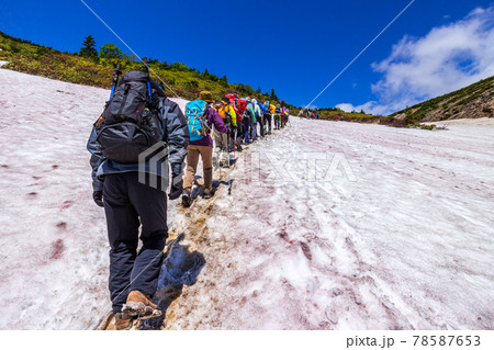 残雪を踏み、一切経山に向かう登山者 78587653