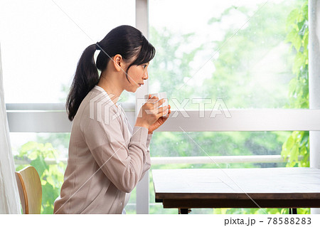コーヒーを飲んで休憩するサマーカーディガンを着た女性 78588283