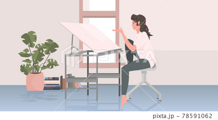 woman architect sitting at workplace with adjustable drawing board desk woman architect sitting at workplace with adjustable drawing board desk 78591062