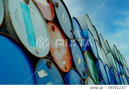 Old chemical barrels stack. Blue and red oil drum. Steel oil tank. Toxic waste warehouse. Hazard chemical barrel. Industrial waste in tank. Hazardous waste. Rusty oil drum stack. Brent crude oil. 78592237