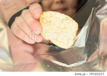 ポテトチップスを食べる女性、袋の中 78593037