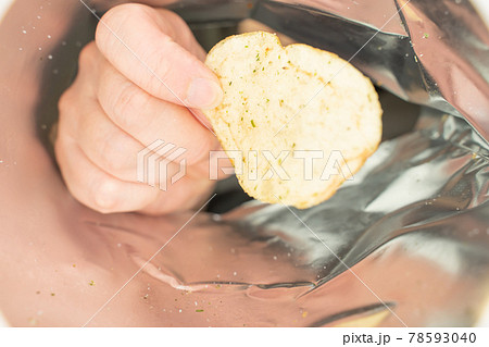 ポテトチップスを食べる女性、袋の中 78593040