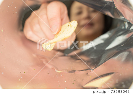 ポテトチップスを食べる女性、袋の中 78593042