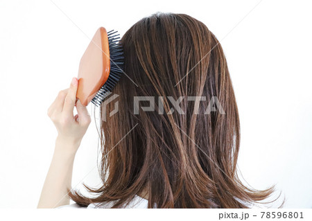 髪をブラシでとかす女性の写真素材