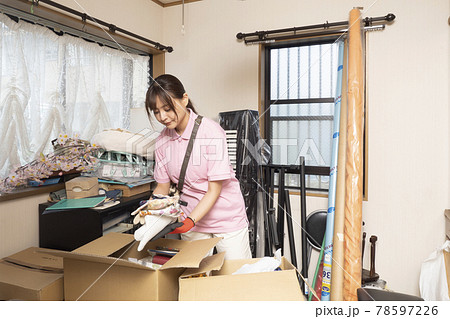 散らかった部屋の片付けをする女性作業員 散らかった部屋の片付けをする女性作業員 78597226