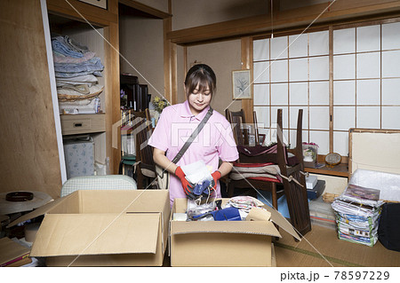 散らかった部屋の片付けをする女性作業員 散らかった部屋の片付けをする女性作業員 78597229