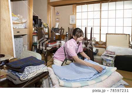 散らかった部屋の片付けをする女性作業員 78597231