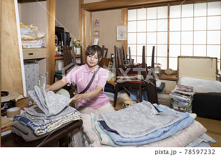 散らかった部屋の片付けをする女性作業員 散らかった部屋の片付けをする女性作業員 78597232