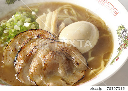 炙りチャーシューや味玉、メンマや万能葱が入ってる熱々の豚骨醤油ラーメンを白背景で撮影 78597316