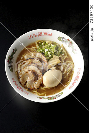 炙りチャーシューや味玉、メンマや万能葱が入ってる熱々豚骨醤油ラーメンを黒背景で俯瞰撮影 78597450