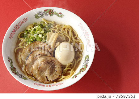 炙りチャーシューや味玉、メンマや万能葱が入ってる熱々豚骨醤油ラーメンを赤色の背景で俯瞰撮影 炙りチャーシューや味玉、メンマや万能葱が入ってる熱々豚骨醤油ラーメンを赤色の背景で俯瞰撮影 78597553