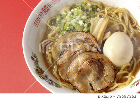 炙りチャーシューや味玉、メンマや万能葱が入ってる熱々豚骨醤油ラーメンを赤色の背景で俯瞰撮影 炙りチャーシューや味玉、メンマや万能葱が入ってる熱々豚骨醤油ラーメンを赤色の背景で俯瞰撮影 78597562