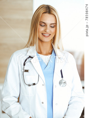 Doctor woman controls medication history records and exam results while using clipboard in sunny hospital . Medicine and healthcare concept 78598474