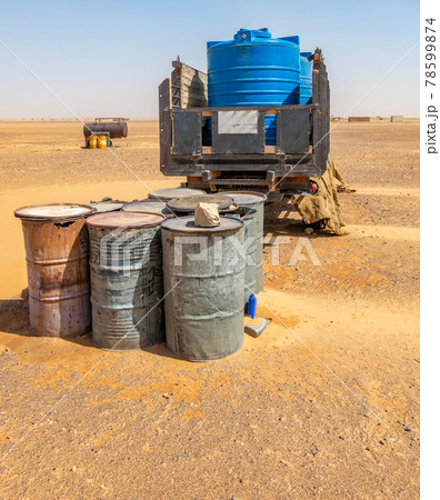 Water wagons and water barrels in the middle of the desert of Sudan 78599874