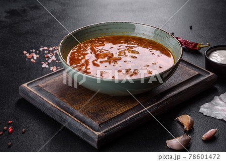 Delicious fresh hot borsch with tomato and meat in a ceramic plate Delicious fresh hot borsch with tomato and meat in a ceramic plate 78601472
