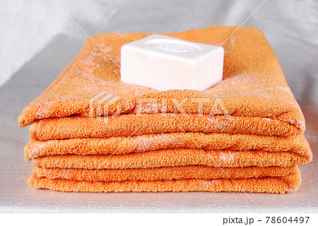 White aromatic, fragrant soap bars and orange towel White aromatic, fragrant soap bars and orange towel 78604497
