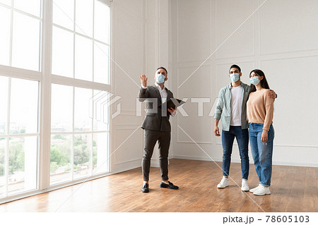 Estate Agent In Medical Mask Showing Buyers New Apartment Estate Agent In Medical Mask Showing Buyers New Apartment 78605103