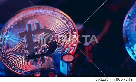 Bitcoin and semiconductor. Represent mining in Cryptocurrency cause global warming. Bitcoins on CPU board. Close-up Bitcoin with blue and pink light. circuit board with coin. Online asset concept. Bitcoin and semiconductor. Represent mining in Cryptocurrency cause global warming. Bitcoins on CPU board. Close-up Bitcoin with blue and pink light. circuit board with coin. Online asset concept. 78607248